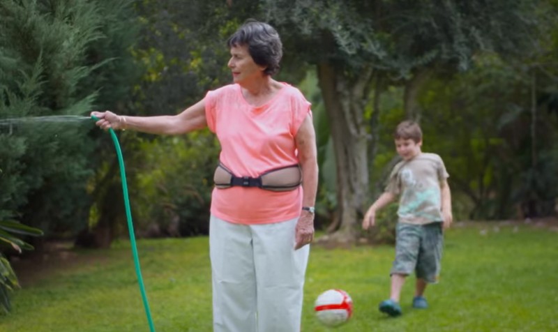 Une dame âgée qui arrose son jardin et porte la ceinture HipHope