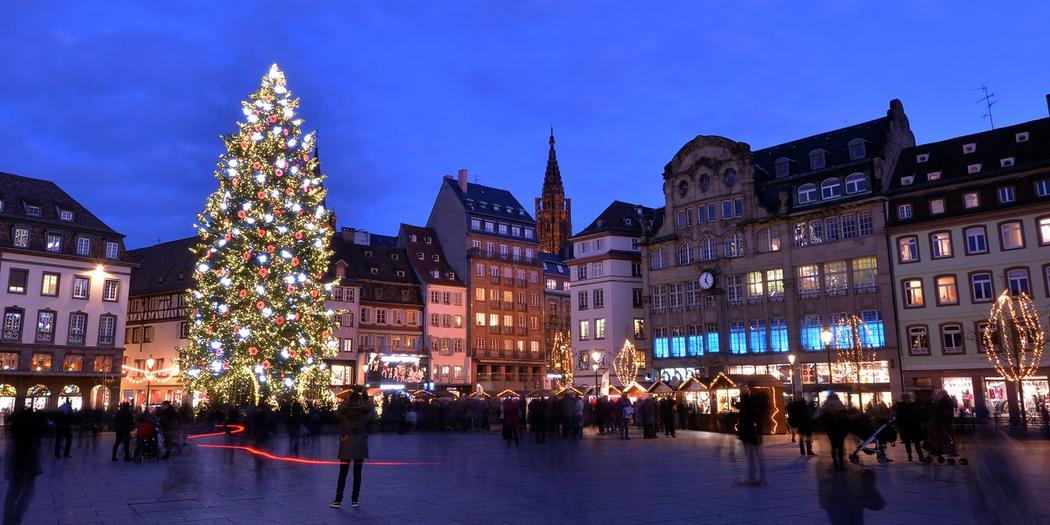 un sapin de noel illuminé sur la place principale d'une ville