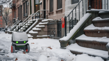 Un robot de livraison roulant dans la neige dans une rue